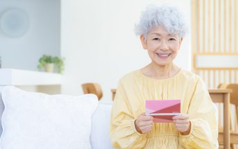 観葉植物に水をやるシニアの女性